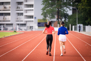 Obraz premium Young fitness woman runner jogging excercise in the morning on city stadium track in the city. Female athlete excercise in the city stadium to keep body fitness. Stock photo.