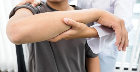 Obraz premium Female physiotherapists provide assistance to male patients with elbow injuries to examine patients in rehabilitation centers. Rehabilitation physiotherapy concept