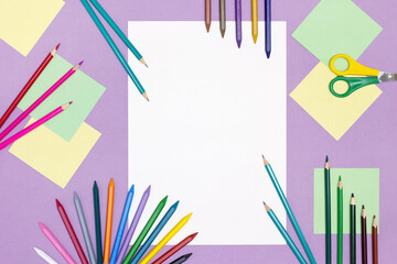 Blank paper, bright colored pencils, scissors on the table. Children's creativity concept with copy space