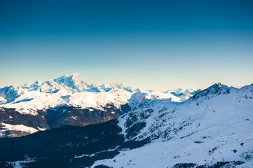 Fototapeta na wymiar Ski resort in winter mountains. Panoramic view of Mont Blanc mountain ridge. Meribal, 3 Valleys, France. Beautiful winter landscape of mountains at sunset