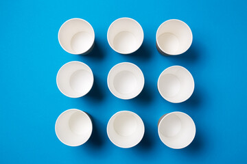Paper cup for hot coffee or tea on a blue isolated background.