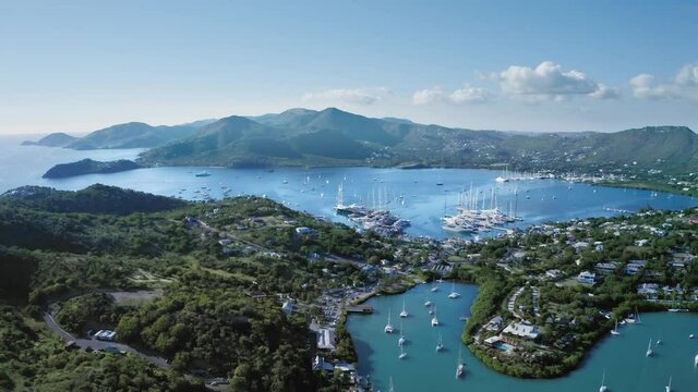 Drone descends to the yachts in the bay of the coastal city at Falmouth Harbour, Antigua and Barbuda