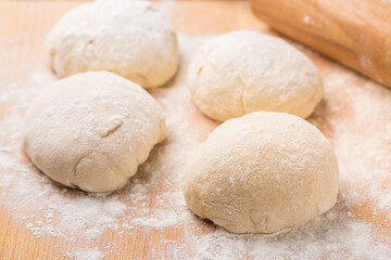 Fototapeta na wymiar Freshly prepared yeast dough for pizza or bread on wooden background.