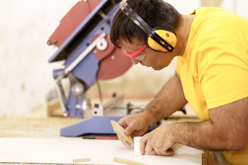 Skilled carpenter making furniture in workshop, fitting parts for wooden furniture. Profession concept