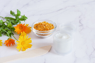 Obraz na płótnie Canvas Herbal cosmetics with calendula flowers. Natural organic moisturizer cleansing product.