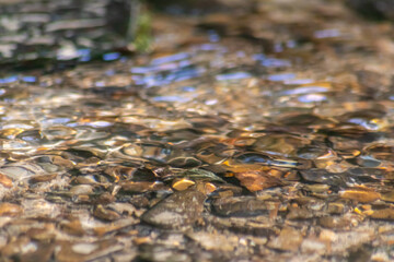 Silky ripples in water of a crystal clear water creek as idyllic natural background with high angle view shows zen meditation and little waves in a healthy mountain spring with a clear floating stream