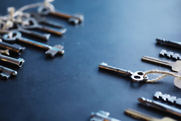 Fototapeta premium Set of vintage keys for a lock. Retro keys on a dark stone background. The concept of choosing the path to achieve the goal.