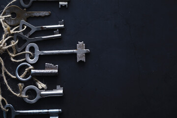 Set of vintage keys for a lock. Retro keys on a dark stone background. The concept of choosing the...