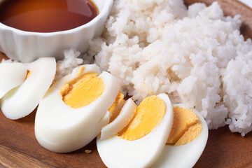 Rice, boiled eggs and sauces in a wooden dish