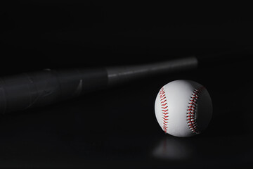 American traditional sports game. Baseball. Concept. Baseball ball and bats on a black table.