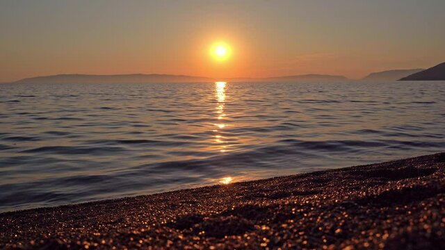 4K footage of a crimson sunset over the mediterranean sea. Show at Kovacine beach in cres island, croatia, on the adriatic sea