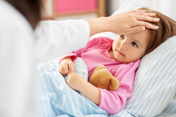 healthcare, medicine and people concept - close up of doctor measuring temperature of little sick girl lying in bed at home