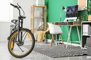 Stylish interior of room with workplace and bicycle