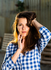 Obraz premium Young woman farmer posing on camera outdoors on background of hothouse buildings..