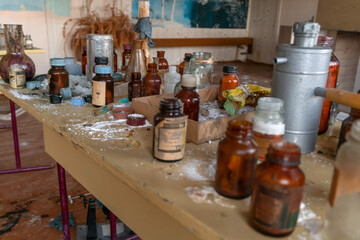 table with old chemical reagents in a classroom in an abandoned school, an abandoned chemistry office