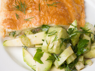 Omelet and fresh cucumber salad. Appetizing breakfast on a white round plate. Close-up