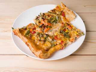 Homemade delicious pizza. The pieces are on a round white plate. Traditional cuisine