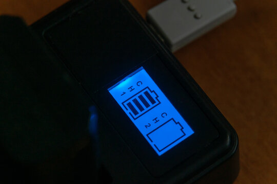 Luminous indicator of the camera battery charger. process of charging the camera's batteries
