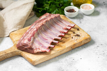 Lamb meat. Lamb ribs on a wooden chopping Board on the light gray kitchen table. Raw lamb meat on the table, loin