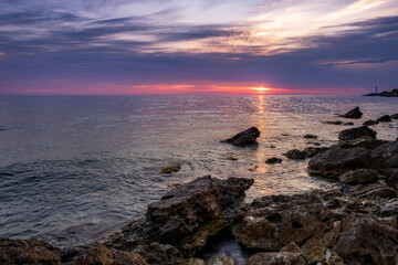 Dramatic sunset over beach with a natural pond in the foreground.