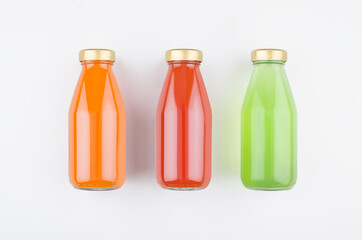 Organic vegetables juices - red tomato, carrot and spinach in glass bottles on white background, mock up for design, advertising, branding product.