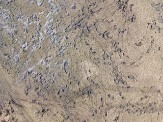 Traces of construction equipment on the soil, aerial view. Lifeless land, wasteland.