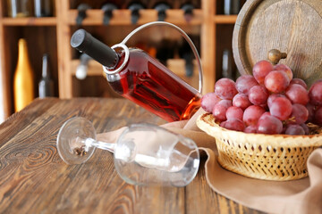 Holder with bottle of wine and glass on table in cellar