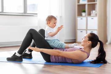 Fototapeta na wymiar family, sport and motherhood concept - happy smiling mother with little baby exercising at home