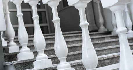 white marble balusters and stone stair case near entry to luxury villa or hotel