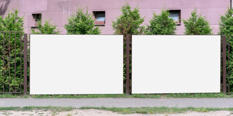 two big white empty banners hanging on metal fence with blank mock-up for commercial information rental housing concept