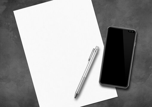 Sheet of paper, pen and smartphone on a concrete desk