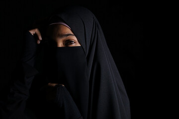 Portrait of Beautiful Muslim Woman in niqab on black background