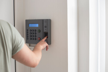 Side view of hand scanning fingerprint to screening system gain entry security to building. Biometric locks control access to record working time