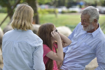 Fototapeta premium happy family of father, mother and daughter in park . Family and Insurance concept.