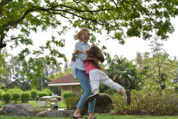 Naklejka premium happy family of mother and daughter in park . Family and Insurance concept.