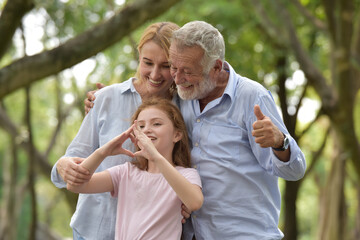 Fototapeta premium happy family of father, mother and daughter in park . Family and Insurance concept.