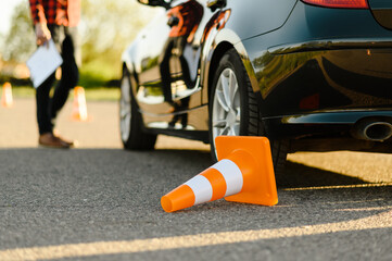 Male instructor at the car, downed traffic cone