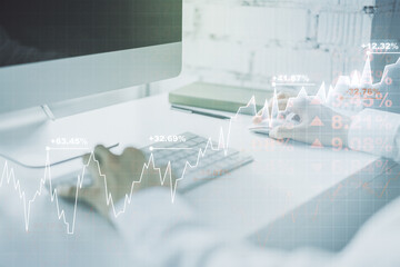 Multi exposure of abstract financial graph with hand typing on laptop on background, financial and trading concept