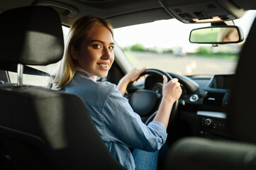 Fototapeta na wymiar Smiling female student in the car, driving school