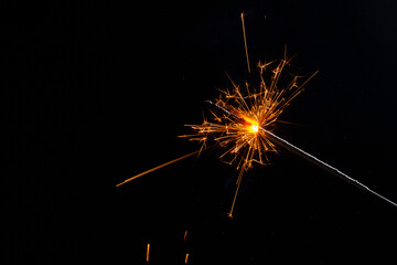 A lit sparkler showing bright sparks