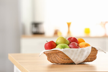 Basket with fresh fruits on table in kitchen
