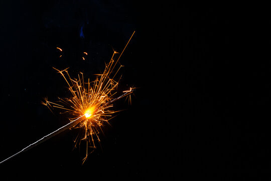 A lit sparkler showing bright sparks