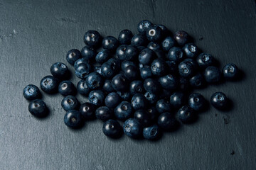 Freshly juicy picked blueberries on dark background. Top view. Selective focus. Free text space. 
