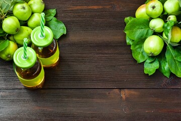 Fresh green apples with leaves and juice on a wooden background. Top view, copy space. Harvest...
