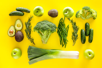Greeny cocktail ingredients.Green vegetables background. Сucumber, avocado, broccoli, beans, leek and fresh apple on Yellow background top view
