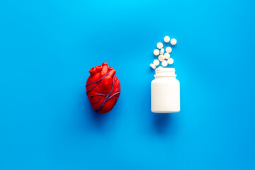 Heart and treatment. Heart near pills tonometer, treatment  on blue background top view