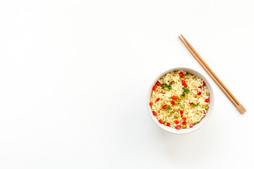 Instant noodle with pepper,peas, chopstick and greens. White background top view copy space