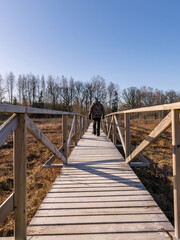 a male figure on a wooden footbridge