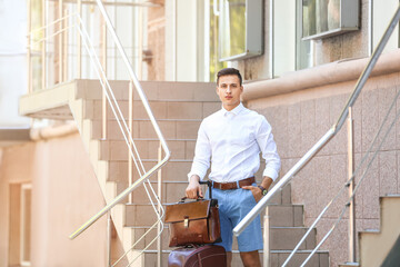 Fototapeta premium Young man with stylish bags near shop outdoors