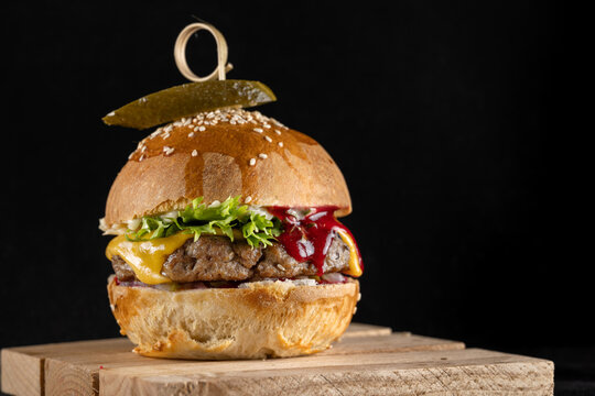 Homemade burger with lingonberry jam, beef patty and pickles.